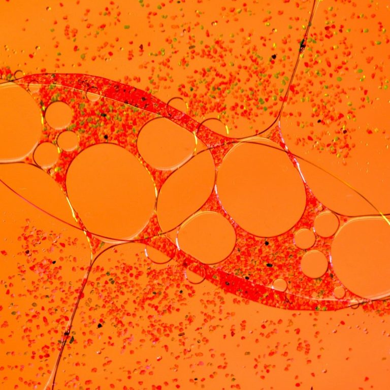 Aumento íntimo masculino Estructura abstracta con formas redondas sobre un fondo naranja vibrante. Aumento íntimo masculino.